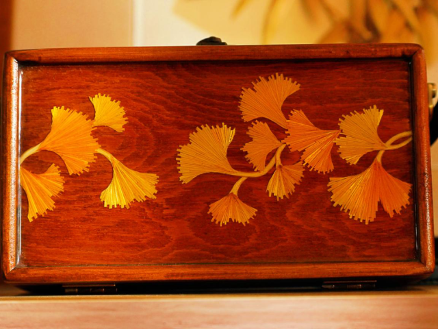 麦秆在手艺人的手下变成叶脉清晰的银杏树叶装贴在首饰盒上。