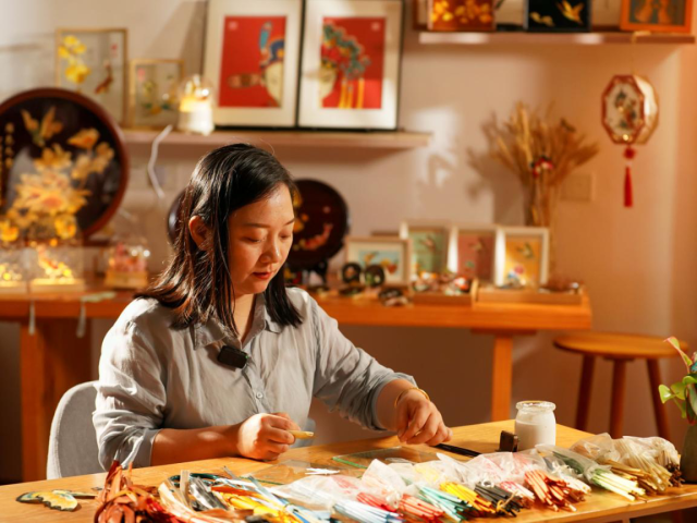 郑烨娃在自己的工作室制作潮州麦秆画。