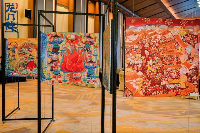 “龙门阵”农民画作品展上，色彩明艳、画风生动的农民画展示龙门县乡土风情和民间习俗。