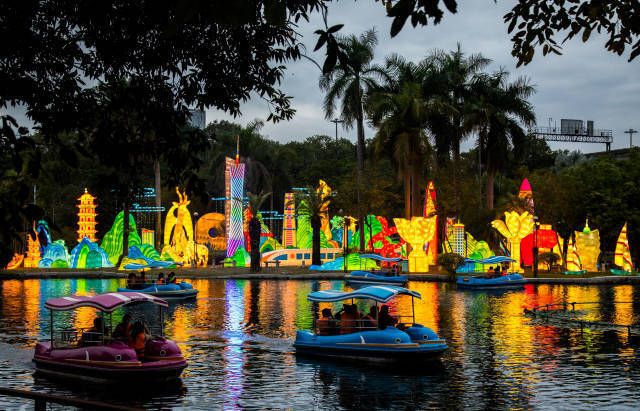 一边游船，一边欣赏湖边灯饰，良辰美景赏心悦目。吴秒衡 谭家富摄