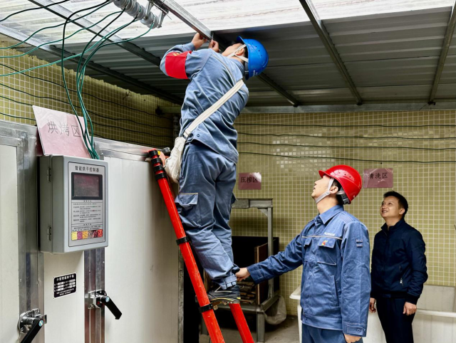供电局志愿服务队的师傅们正在安装烘干设备。