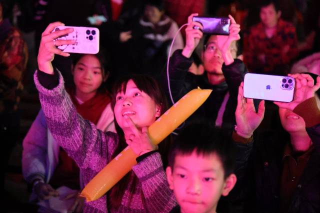 精彩的节目，让人忍不住拿出手机记录下来。（董逊 摄）