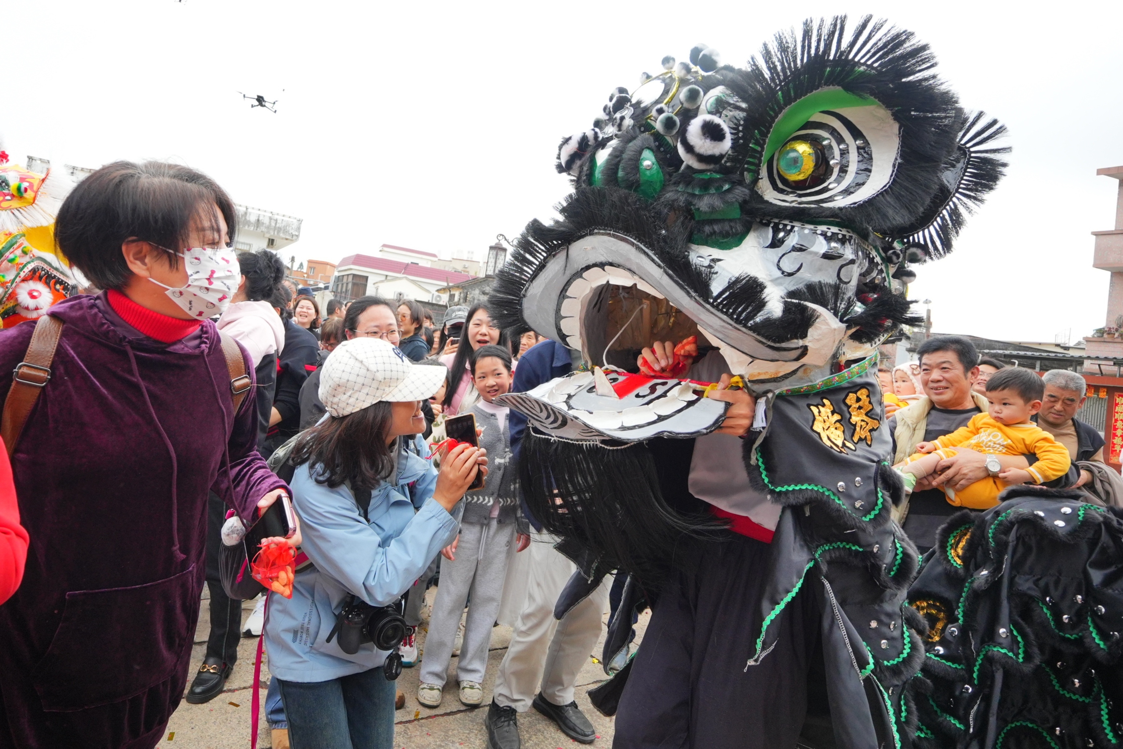 游客与传统醒狮亲密互动。&nbsp;