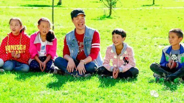 支教过程中，苏秋欢利用课余时间和班级学生坐在草坪上放歌。