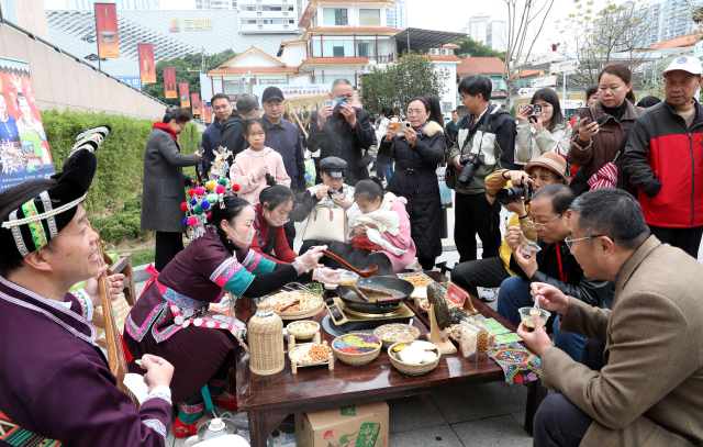 现场游客体验侗族美食