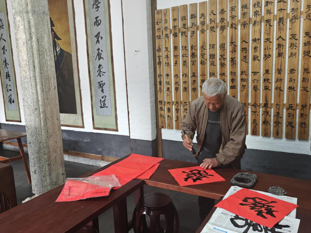 世兴家塾厅堂中央，村民挥毫泼墨（受访者供图）