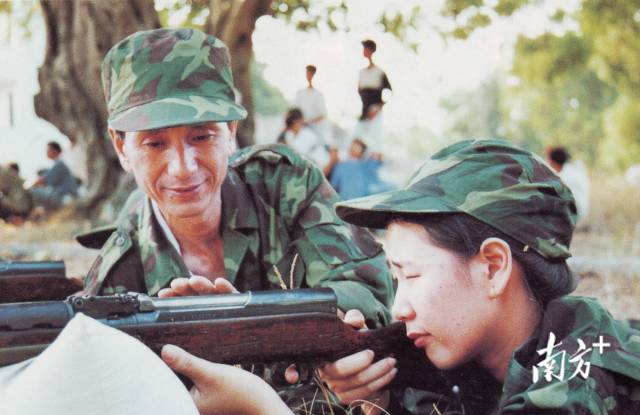 △女民兵林志芳(右)手持步枪瞄准前方,同为民兵的父亲林煜在一旁指导。 △女民兵林志芳(右)手持步枪瞄准前方,同为民兵的父亲林煜在一旁指导。