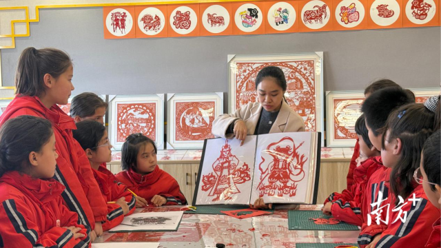 广州援疆教师陆婉静向学生展示《哪吒之魔童闹海》人物剪纸。