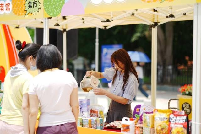 攤位負(fù)責(zé)人給市民準(zhǔn)備特色飲品試飲。