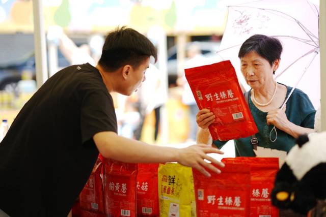 攤位負(fù)責(zé)人在積極向市民推介特色農(nóng)產(chǎn)品。