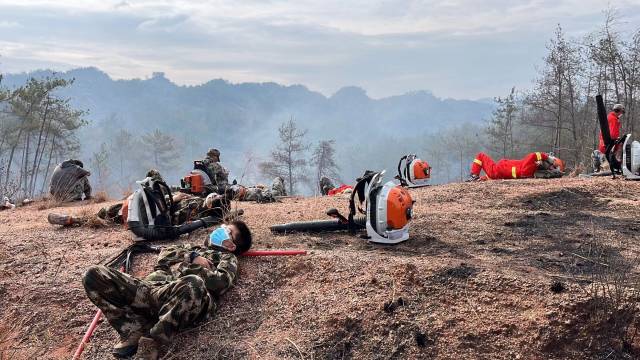 钟威（左下）与肖康一起参与山火救援。