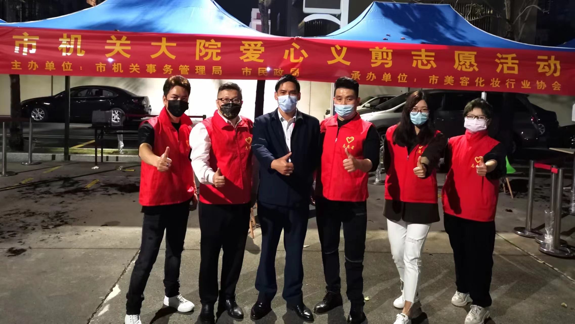 疫情防控期间，朱锡勇（右三）组织志愿者到市机关大院开展义剪活动。