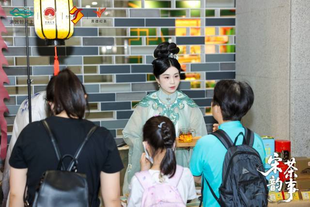 乘客在活动现场品茗。