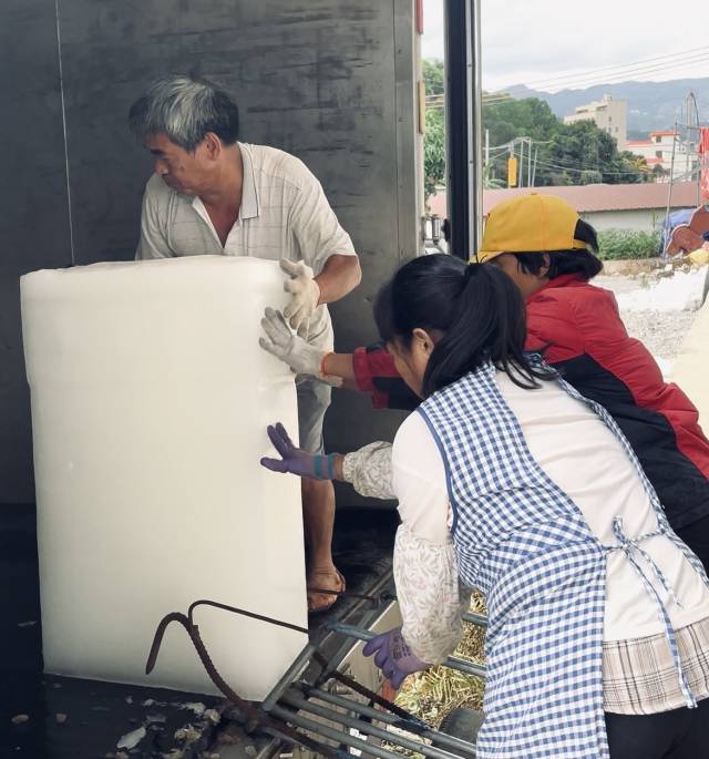 工人将冰块装车。