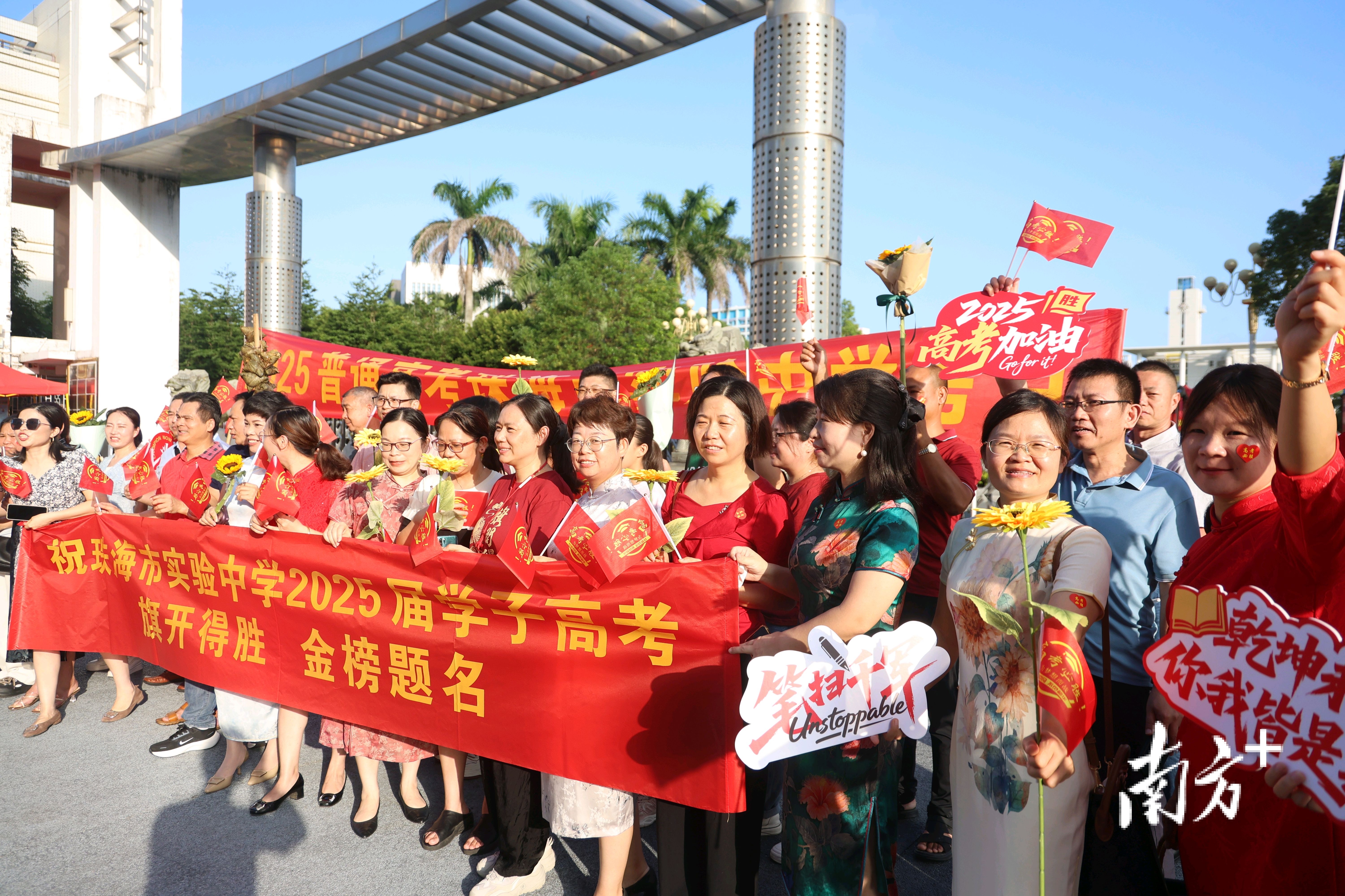 清晨，家长们手持鼓劲标语，为考生加油助威。