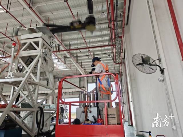 广州检验中心测试车间内，青年工程师正在进行低空飞行器卡车风洞台架的样件安装高度。
