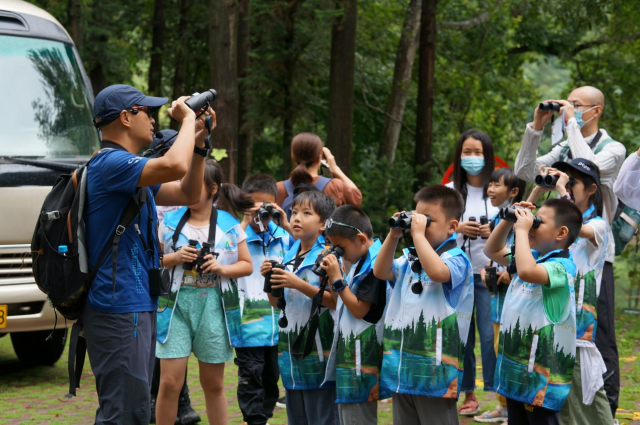 自然教育导师在向学员们指导观鸟技巧  