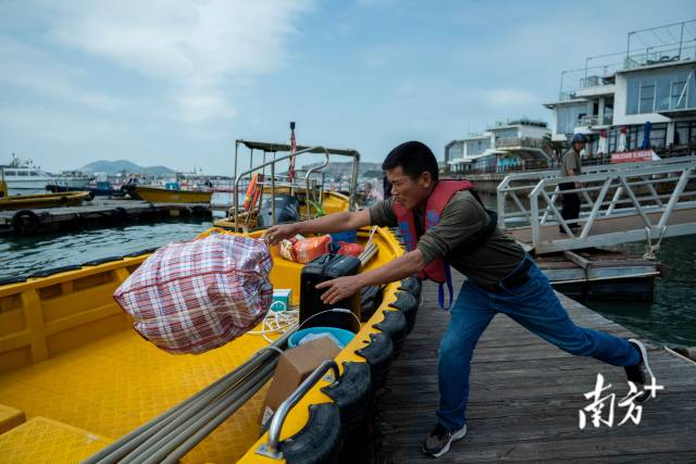 4月8日,珠海桂山岛,老渔民叶悦和将行李扔到船上,他将乘船前往“格盛1号”养殖平台工作。 4月8日,珠海桂山岛,老渔民叶悦和将行李扔到船上,他将乘船前往“格盛1号”养殖平台工作。