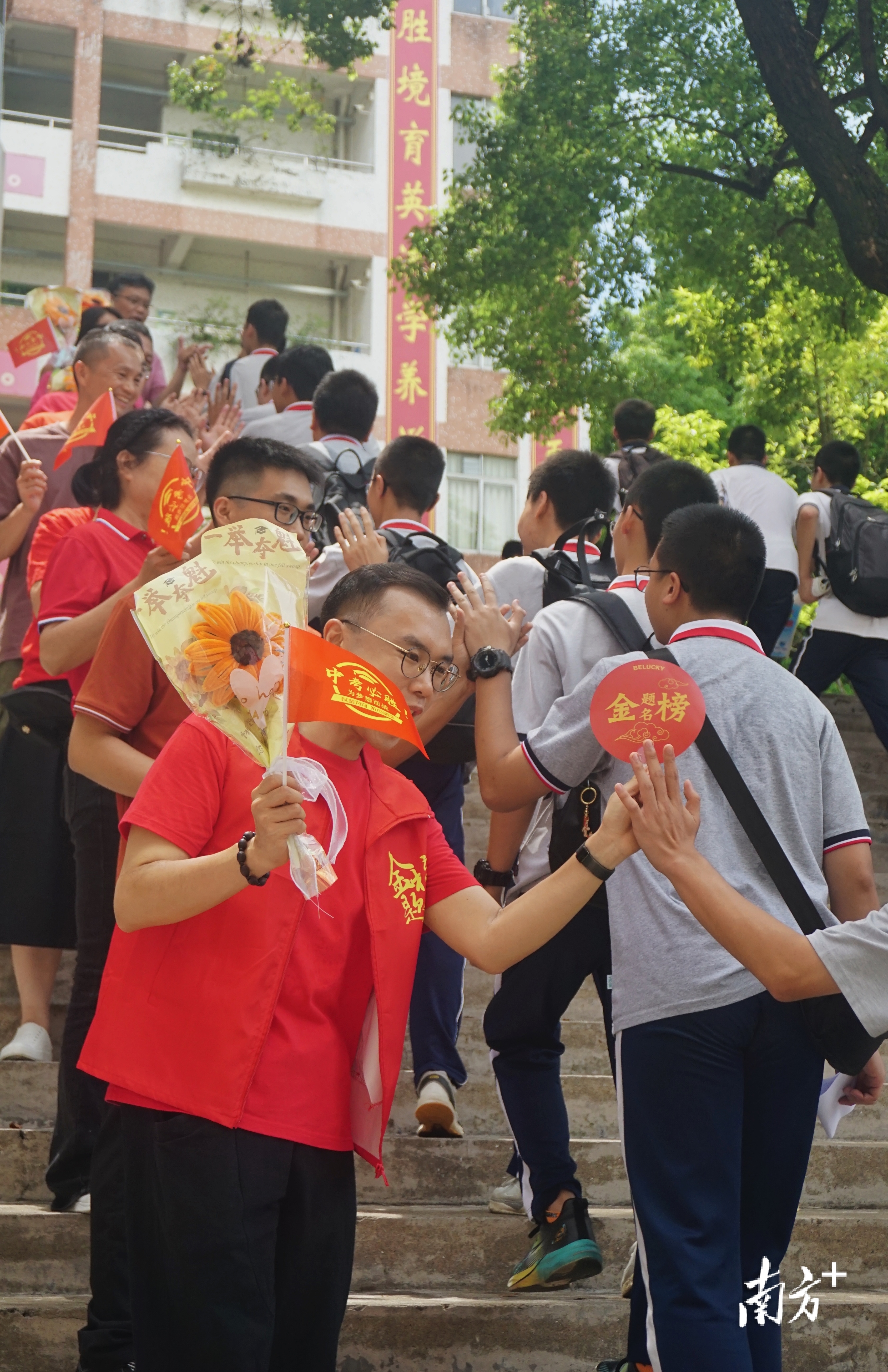 江门市第一中学景贤学校校领导及教师们身穿红衣，列队为初三考生加油鼓劲。 南方+ 黄烨倩 摄