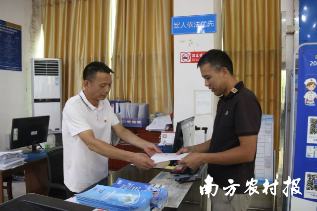 林户林乙有(右)在乡镇林业站拿到采伐许可证。 林户林乙有(右)在乡镇林业站拿到采伐许可证。