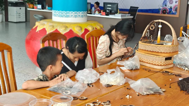 易地搬迁群众陈菊芳在零工市场做手工串珠。