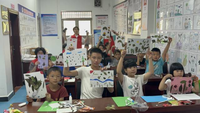 孩子们及其作品合影。