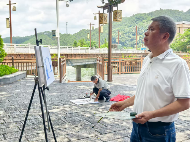 吴共建在画布上勾勒“救人树”线条。