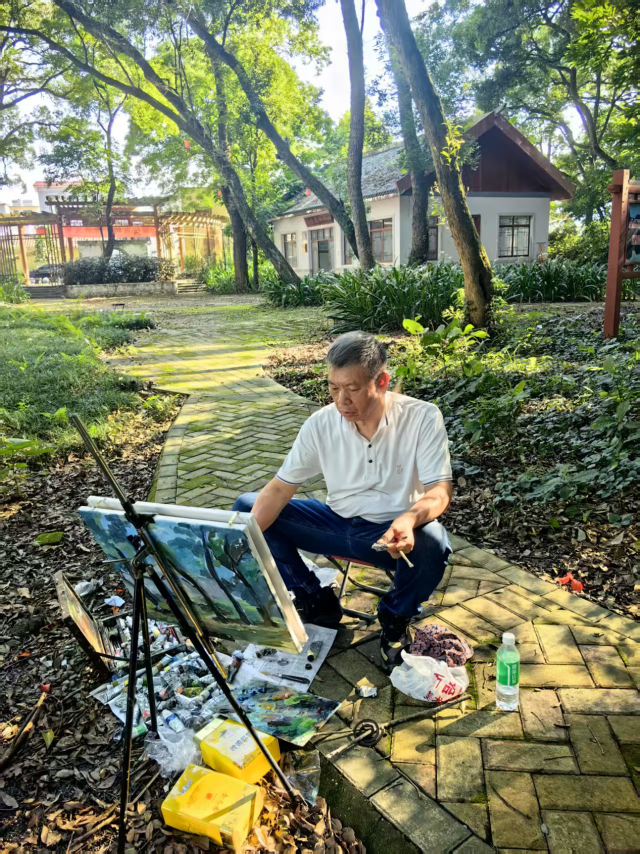 7月26日，吴共建在英德市红旗茶厂采风画古树。