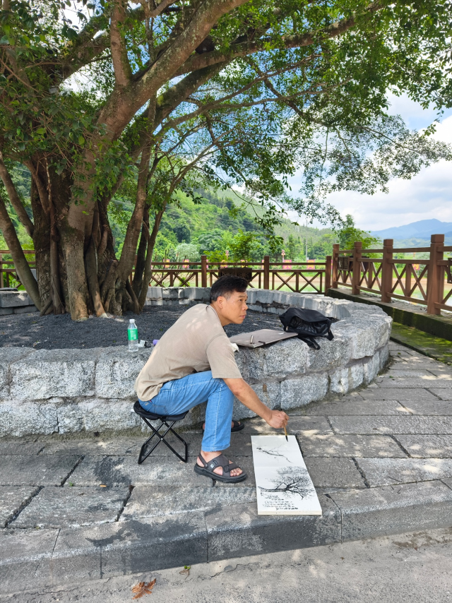 画家在“救人树”下写生。