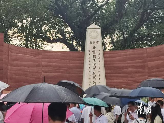 8月14日，马来西亚南侨机工纪念公园内，人们撑着伞冒雨缅怀南侨机工。