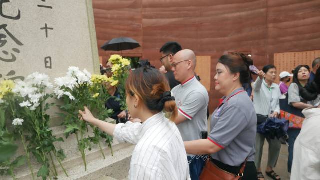 8月14日纪念南侨机工公祭仪式上，马来西亚华裔青年向纪念碑献花。