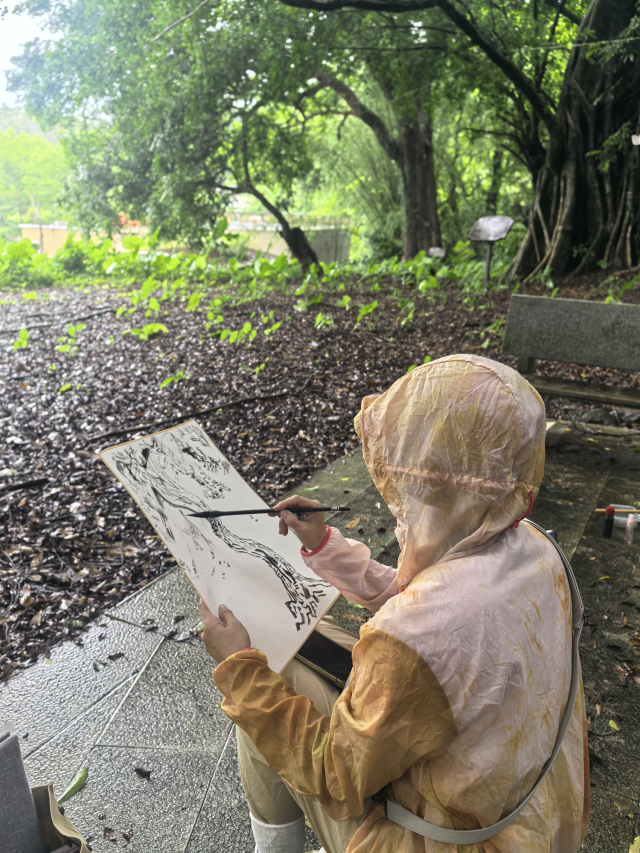 林素花在树下写生。 林素花在树下写生。