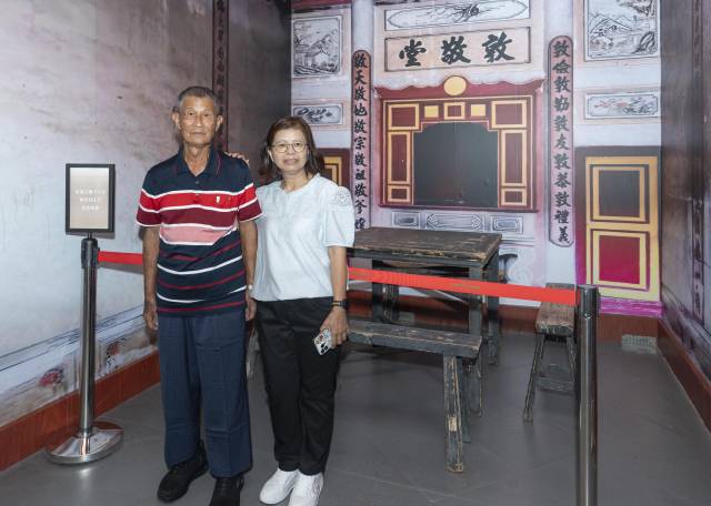 展览展出中国文化名人大营救期间,民主人士与文化名人在新界元朗十八乡大棠村杨家祠留宿期间用过的桌凳原物。捐赠者杨永光(左)和家人在展览现场合影留念。 南方+记者 张冠军 摄 展览展出中国文化名人大营救期间,民主人士与文化名人在新界元朗十八乡大棠村杨家祠留宿期间用过的桌凳原物。捐赠者杨永光(左)和家人在展览现场合影留念。 南方+记者 张冠军 摄