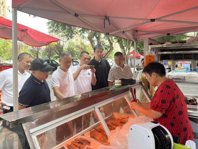 考察团走访夏布小镇卤鹅摊档。