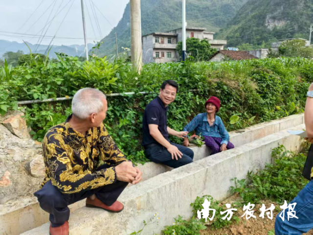 高文忠（左二）正与村民交流。