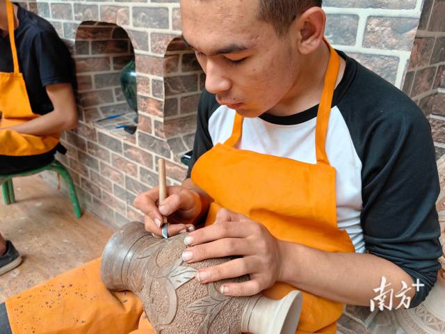 英吉沙县土陶村内，工匠使用传统技法雕刻土陶。南方+ 泠汐 拍摄
