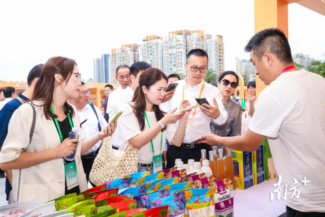 展台前人流不断，消费者一边咨询，一边扫码下单。