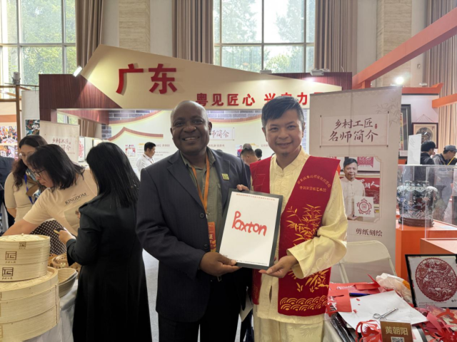 黄朝阳（右）现场演示潮州剪纸技艺。