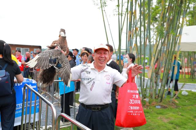 套鸭成功的市民，向镜头展示自己的“战利品”。