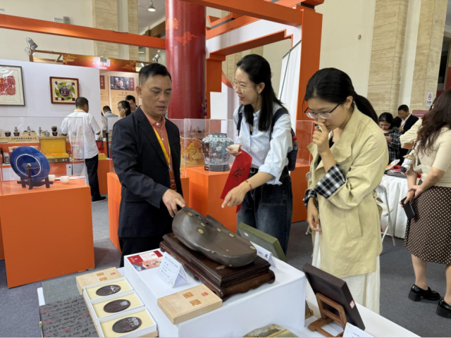 郑天旭（左一）为参观者介绍端砚。