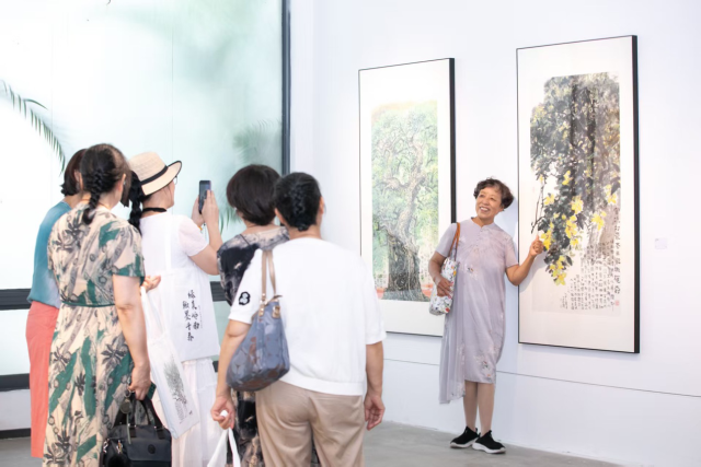市民被书画展吸引而来，纷纷在作品前拍照留念。