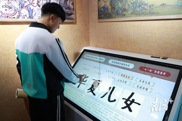 铸牢中华民族共同体意识主题教育馆里，学生们用数字设备学知识。