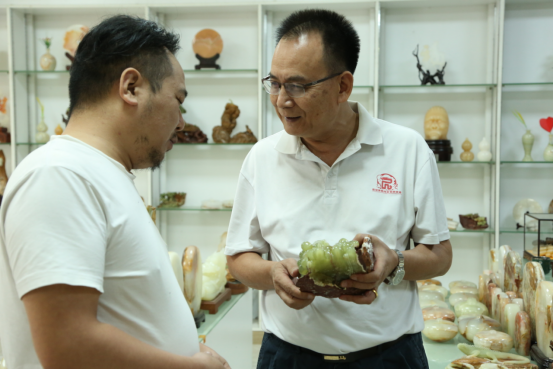 曾云平（右）与向伟（左）交流雕刻技艺。