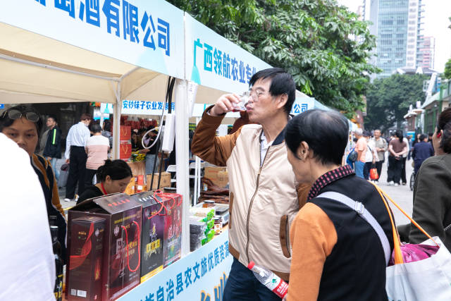 市民试喝野生毛葡萄酒。