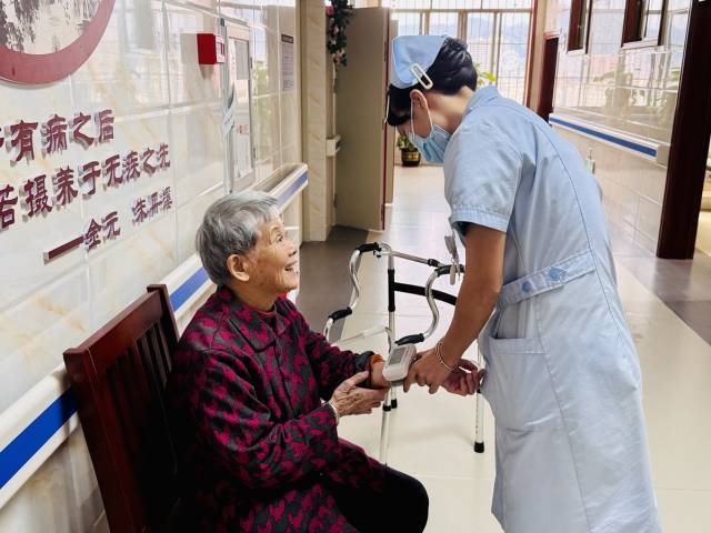 医养结合中心的护士正在给老人量血压。（谢晓莉 摄）