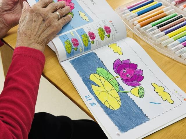 92岁的黄阿婆正在画彩笔画。（谢晓莉 摄）