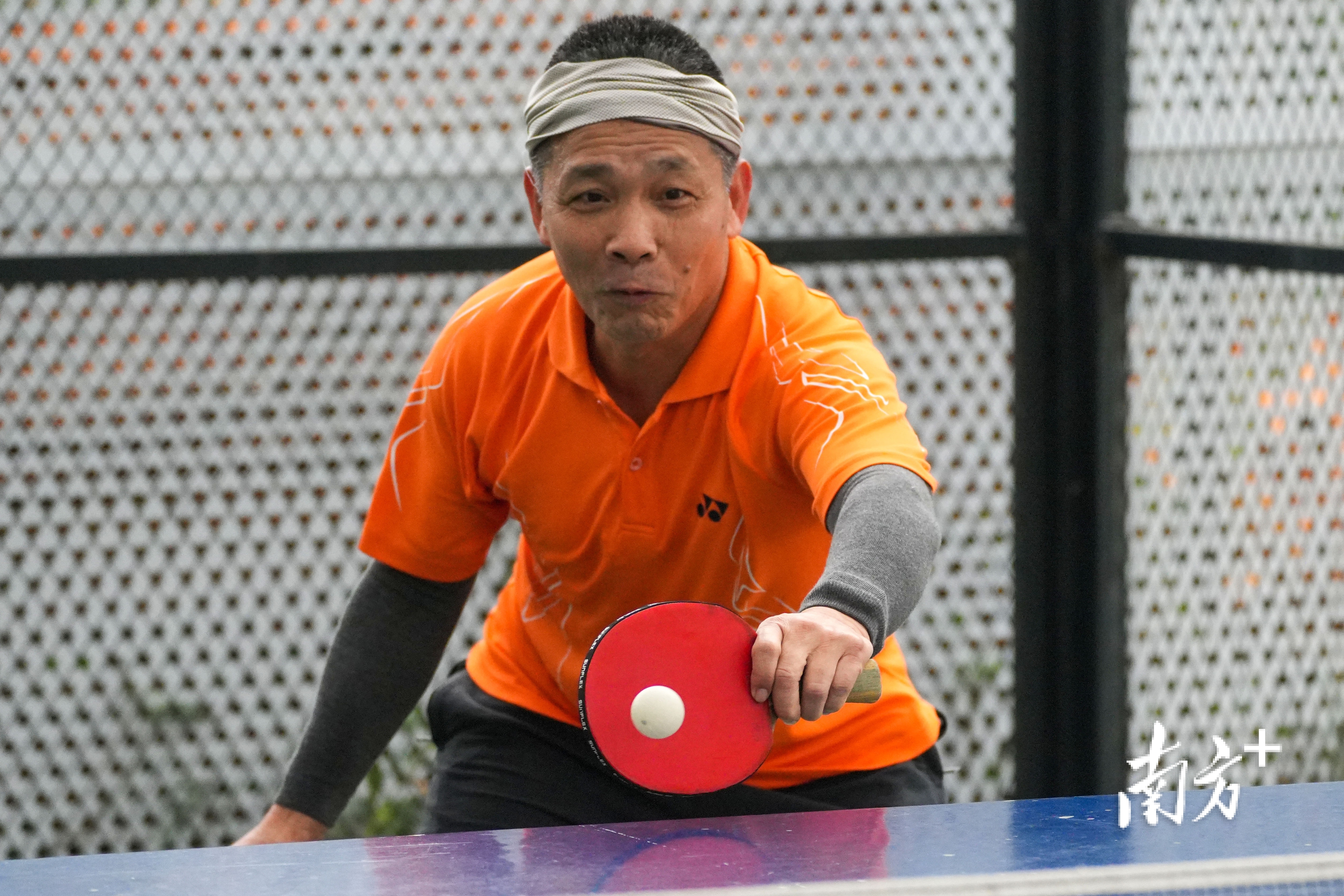 大叔认真挥舞着球拍。  