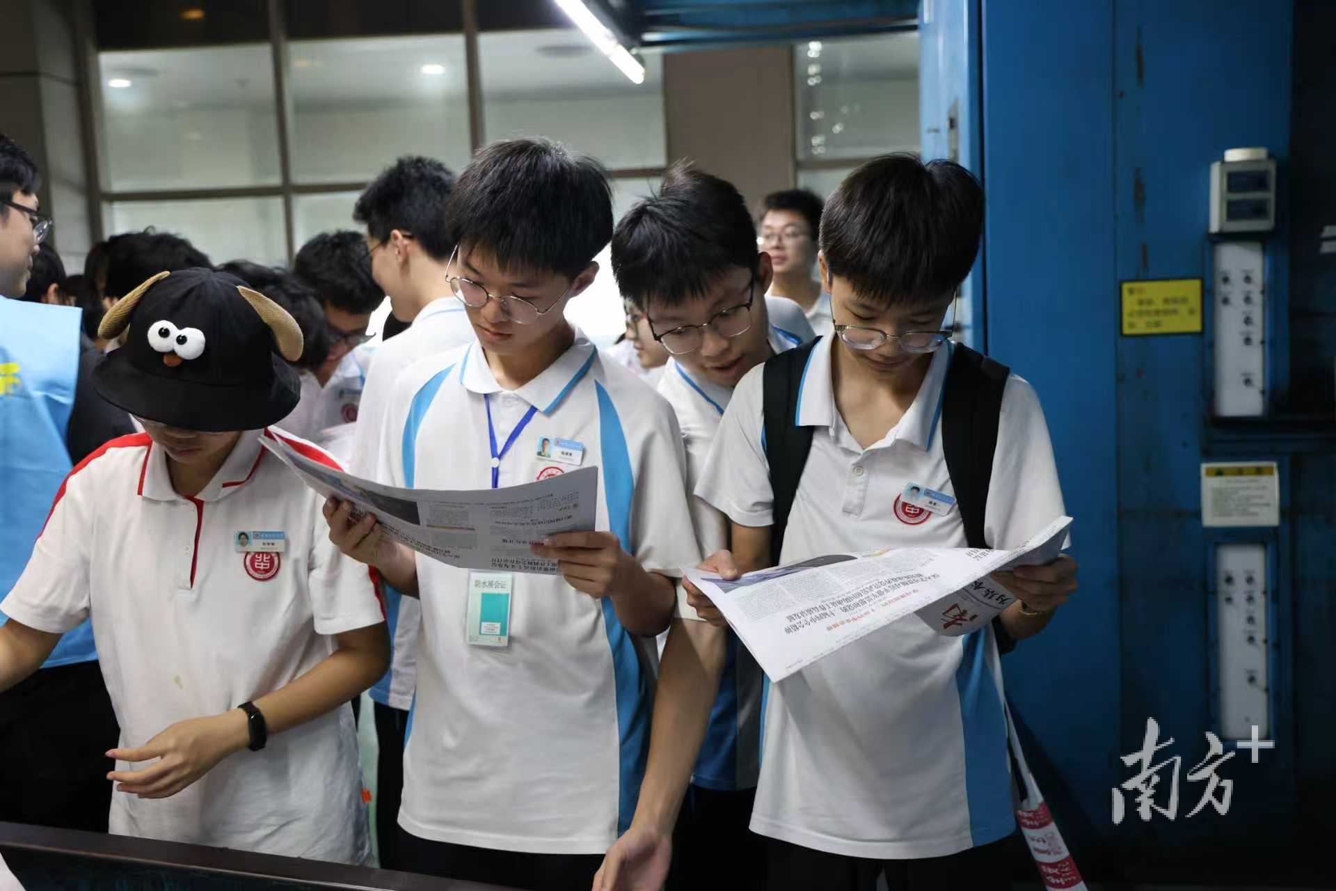 学生们拿到刚印出来的报纸。 学生们拿到刚印出来的报纸。