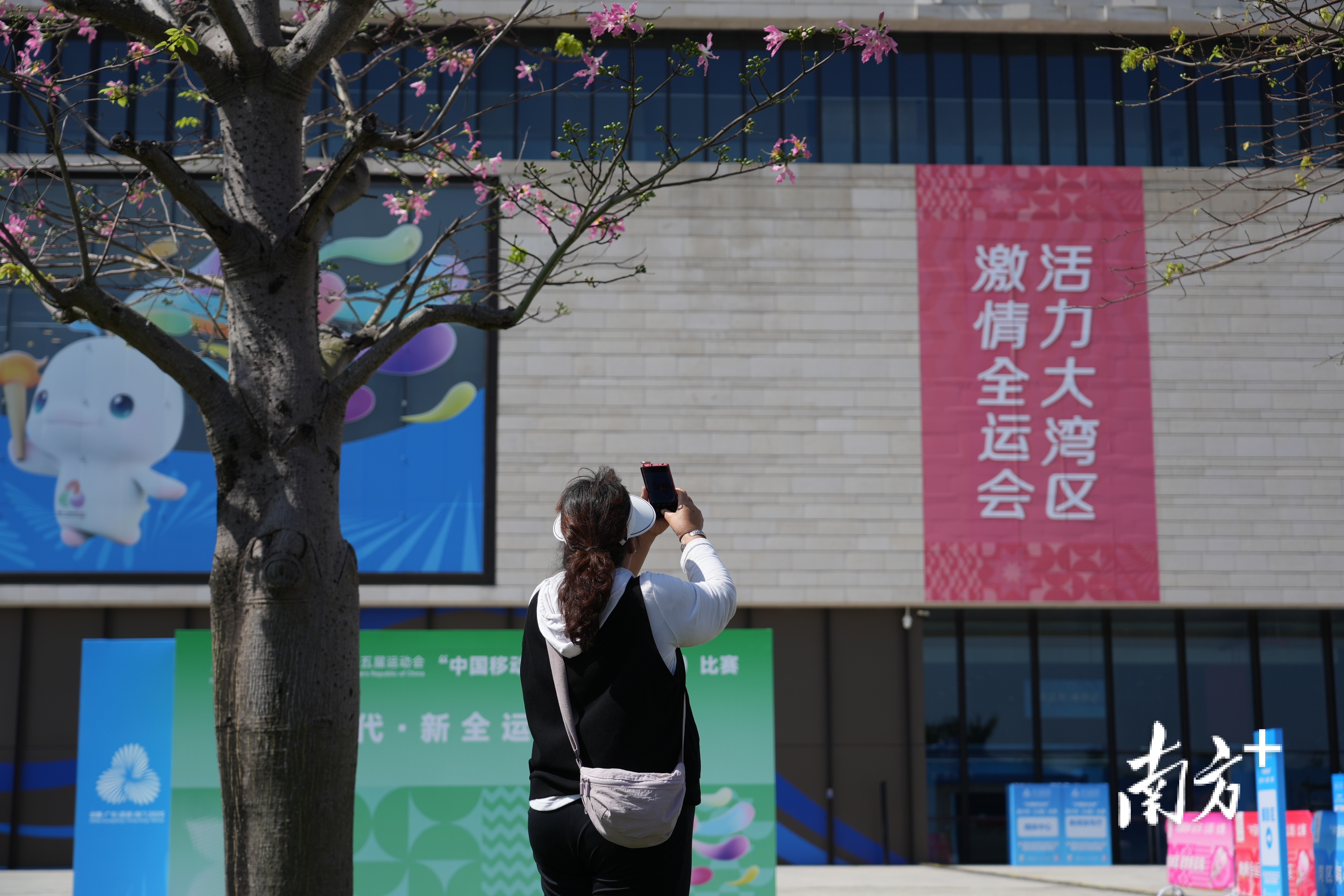 女子在全运会主题海报前打卡。