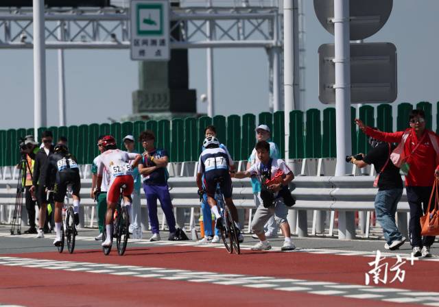 12时04分,选手们纷纷从车队工作人员手中接过补给品。 12时04分,选手们纷纷从车队工作人员手中接过补给品。